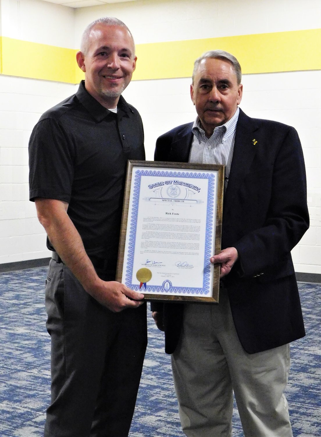 Michigan Speaker of the House Jason Wentworth presents a State of Michigan Special Tribute proclamation to Harrison Community Schools Superintendent Rick Foote during a school celebration held in honor of his career in education